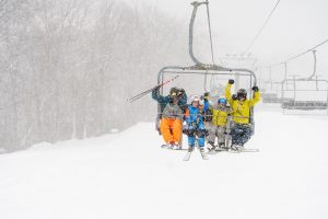 4 skiers on chair lift